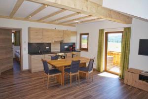 een keuken en eetkamer met een houten tafel en stoelen bij Panoramahof Breher in Hopferau