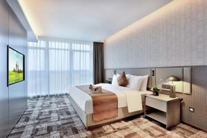 sypialnia z dużym białym łóżkiem i dużym oknem w obiekcie Yiwu Yandoo Yayue Hotel w mieście Yiwu