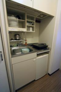 a small kitchen with a sink and a counter at Weekly Green In Namba in Osaka