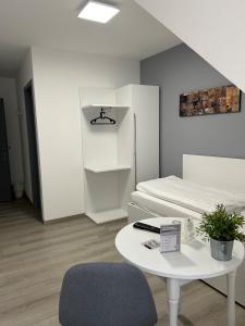 a white room with a table and a bed at Hotel-Fritz in Valwig