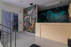 ein Zimmer mit Gemälden an den Wänden und einer Treppe in der Unterkunft SUPER OYO 92300 Koala House in Pekanbaru