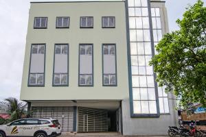 a white building with a car parked in front of it at SUPER OYO 92300 Koala House in Pekanbaru