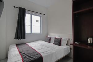 um quarto com uma cama grande e uma janela em SUPER OYO 92300 Koala House em Pekanbaru