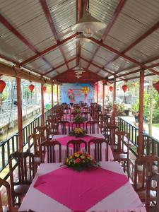 ein Restaurant mit rosa Tischen und Stühlen mit Blumen in der Unterkunft Homestay Pink House (Ngôi nhà màu hồng) in Ấp Ðông Qứi