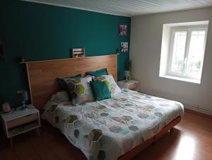 um quarto com uma cama e uma parede verde em LE JR 70 Relais Motards em Magny-dʼAnigon