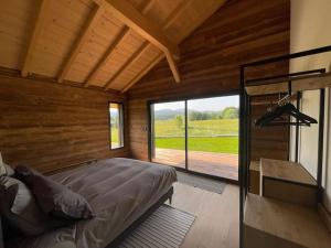 a bedroom with a large bed and a large window at Unique ! Chalet Grand Standing, la Nature pour vis à vis in Les Rousses