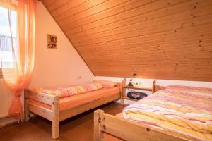 two beds in a room with a wooden ceiling at Ferienhof-Dachsberg Wohnung Weitblick in Bermatingen