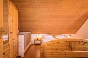 a bedroom with two beds in a wooden room at Ferienhof-Dachsberg Wohnung Weitblick in Bermatingen