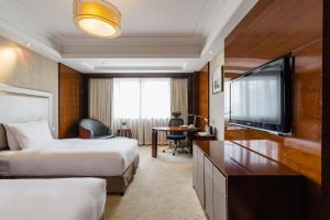 九江的住宿－九江远洲国际大酒店，酒店客房设有两张床和一台平面电视。