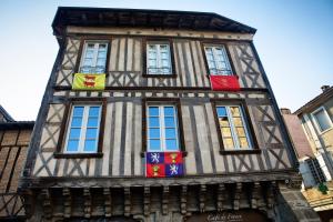 a tall building with flags in front of it at Cafe de france Eauze in Eauze
