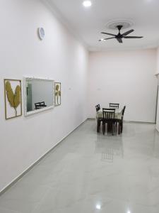 a dining room with a table and a ceiling fan at Homestay Che Naa in Kuantan +13 photos