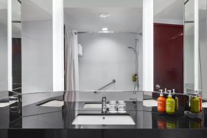 a bathroom with a sink and a large mirror at Holiday Inn Singapore Atrium, an IHG Hotel in Singapore