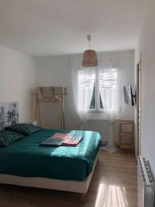 a bedroom with a green bed and a window at Studio avec Piscine in Saint-Médard-en-Jalles