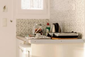 a white kitchen with a counter top with a sink at Litsa Studios in Agia Anna Naxos