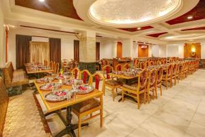 une salle à manger avec des tables et des chaises dans un restaurant dans l'établissement Hotel Yuvraj, à Vadodara