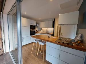 a kitchen with white cabinets and a wooden counter top at barbiccaja in Ajaccio