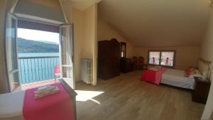 Schlafzimmer mit einem großen Fenster mit Blick auf das Wasser in der Unterkunft Albergo Motta in Sale Marasino