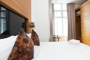 a bedroom with a large white bed with pillows at Dua Sentral by Cobnb in Kuala Lumpur