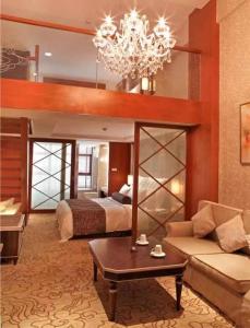 Habitación grande con cama y lámpara de araña. en Best Western Premier Hotel Hefei, en Hefei