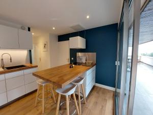 a kitchen with a wooden table and stools at barbiccaja in Ajaccio +22 photos