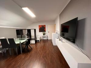 een woonkamer met een eettafel en een grote televisie bij Ferienwohnung in bester Lage Kassels in Kassel