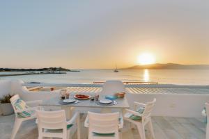 una mesa y sillas en un balcón con vistas al océano en Litsa Studios, en Agia Anna de Naxos