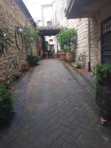 Casa porta San Francesco في Alatri: ساحة مع ممشى حجري مع نباتات الفخار