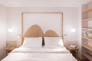 a bedroom with a bed with a large wooden headboard at Hotel Weissenstein in Sankt Michael im Lungau
