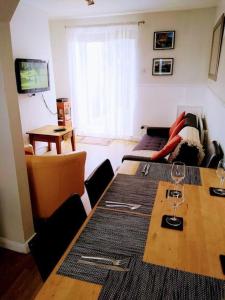 una sala de estar con una mesa con copas de vino. en 2 Bed pet-free cottage, private garden & fell view, en Arlecdon