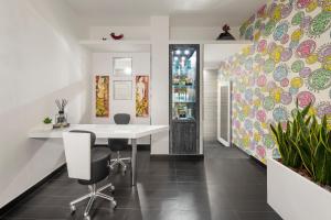 an office with a white table and chairs and a plant at LHP Napoli Palace & SPA in Naples
