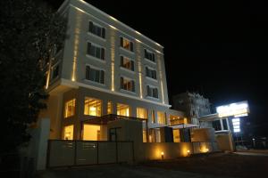 KālapettaiにあるMisty Ocean - A Bergamont Group of Hotelの夜にライトアップされた看板のある大きな白い建物