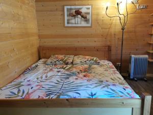 Cama en habitación con pared de madera en Domaine Chez Jem, en Le Breuil