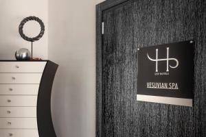 a black door with a sign on it next to a dresser at LHP Napoli Palace & SPA in Naples