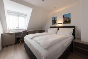 a bedroom with a bed and a desk and a sink at Hotel-Restaurant Sebastianushof in Bonn