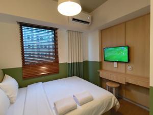 Habitación de hotel con cama y TV de pantalla plana. en Hotel Osaka PIK2 en Tangerang