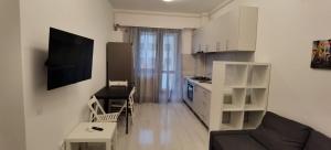 pequeña sala de estar con sofá y cocina en Cozy Accommodation Central City - Iasi en Iaşi