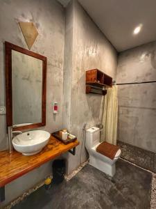 a bathroom with a sink and a toilet and a mirror at Monsoon Riverside Hotel in Phnom Penh
