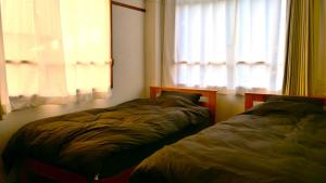 two beds sitting in a room with a window at women only ulala guesthouse - Vacation STAY 44819v in Hagi