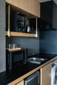 uma cozinha preta com um lavatório e um micro-ondas em Minn Nijojo em Quioto
