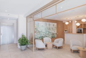 a waiting room with white chairs and a painting at Hotel Weissenstein in Sankt Michael im Lungau