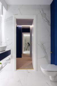 a bathroom with a mirror and a sink and a toilet at Luxury Saphir Gold Mamaia Nord in Mamaia