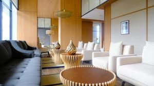 a lobby with white chairs and a table at Hotel Osaka PIK2 in Tangerang