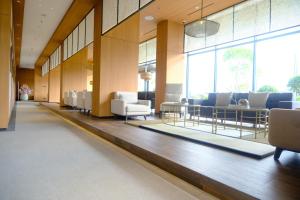Hotel Osaka PIK2 في تانغيرانغ: غرفة انتظار مع كراسي وطاولات ونوافذ