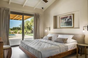 a bedroom with a bed and a sliding glass door at Villa VIRGINIA in Svoronata
