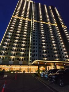 Hotel Osaka PIK2 في تانغيرانغ: مبنى كبير فيه سيارات تقف امامه
