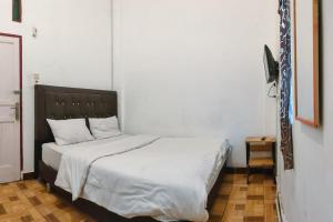 ein Bett in einem Schlafzimmer mit einer amerikanischen Flagge an der Wand in der Unterkunft Johje Guest House Medan Mitra RedDoorz in Medan