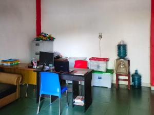 Zimmer mit einem Schreibtisch und einem blauen Stuhl in der Unterkunft Johje Guest House Medan Mitra RedDoorz in Medan