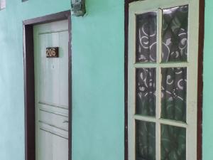 eine Tür und ein Fenster in einer blauen Wand in der Unterkunft Johje Guest House Medan Mitra RedDoorz in Medan
