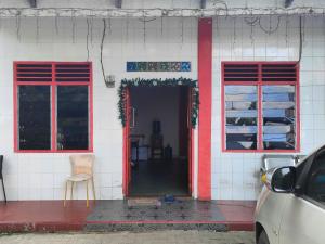 ein Haus mit zwei Fenstern und einer roten Tür in der Unterkunft Johje Guest House Medan Mitra RedDoorz in Medan + 3 Fotos
