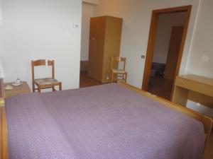 1 dormitorio con 1 cama grande y 2 sillas en Hotel Bel Sit en Comano Terme